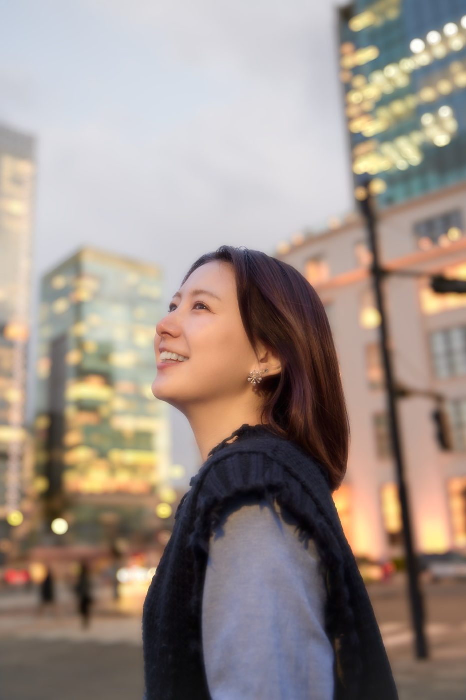 街で空を見上げる女性